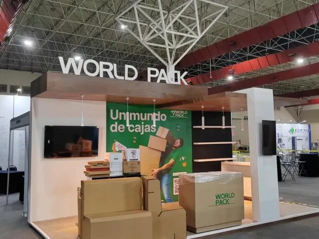 Stand ferial instalado para World Pack con la frase "Un mundo de cajas" en fondo verde, en Monterrey